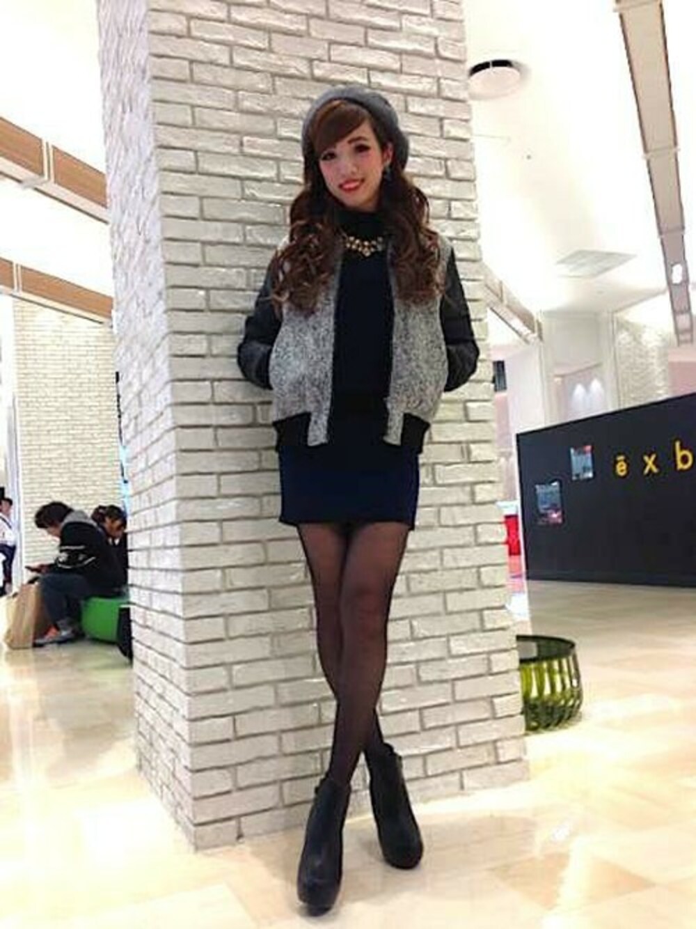 ホワイト系のスタジャン、グリーン系のニット/セーター、グリーン系のスカートを着用したレディースの冬コーディネートの1枚目の写真