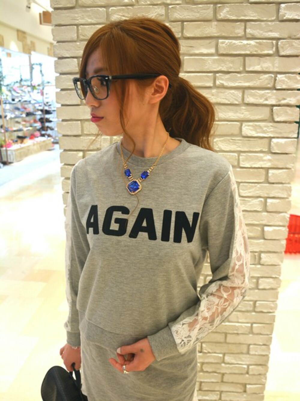 グレー系のスウェット、グレー系のスカート、ブラック系のバックパック/リュックを着用したレディースの春コーディネートの1枚目の写真