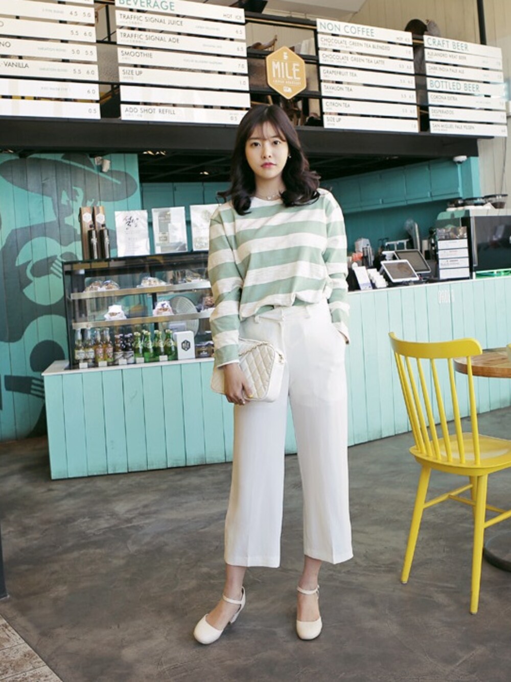 グリーン系のTシャツ/カットソー、ベージュ系のパンプスを着用したレディースの冬コーディネートの1枚目の写真
