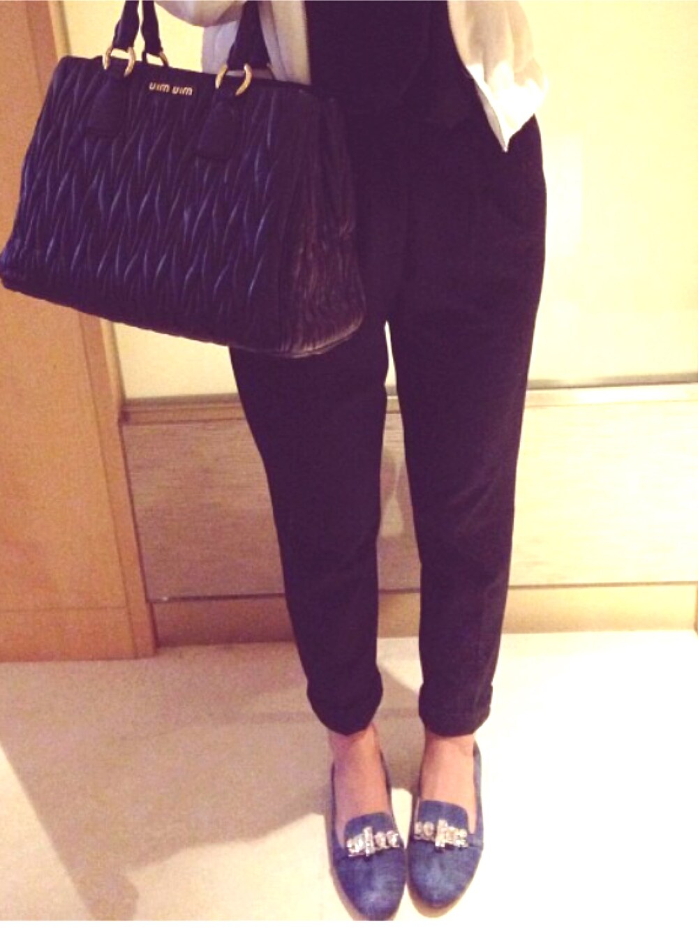 ブラック系のトートバッグ、ブラック系のチノパンツ、ブルー系のモカシン/デッキシューズを着用したレディースの夏コーディネートの1枚目の写真