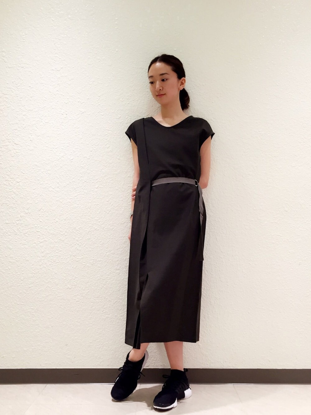 グリーン系のワンピース、ブラック系のスニーカーを着用したレディースの夏コーディネートの1枚目の写真