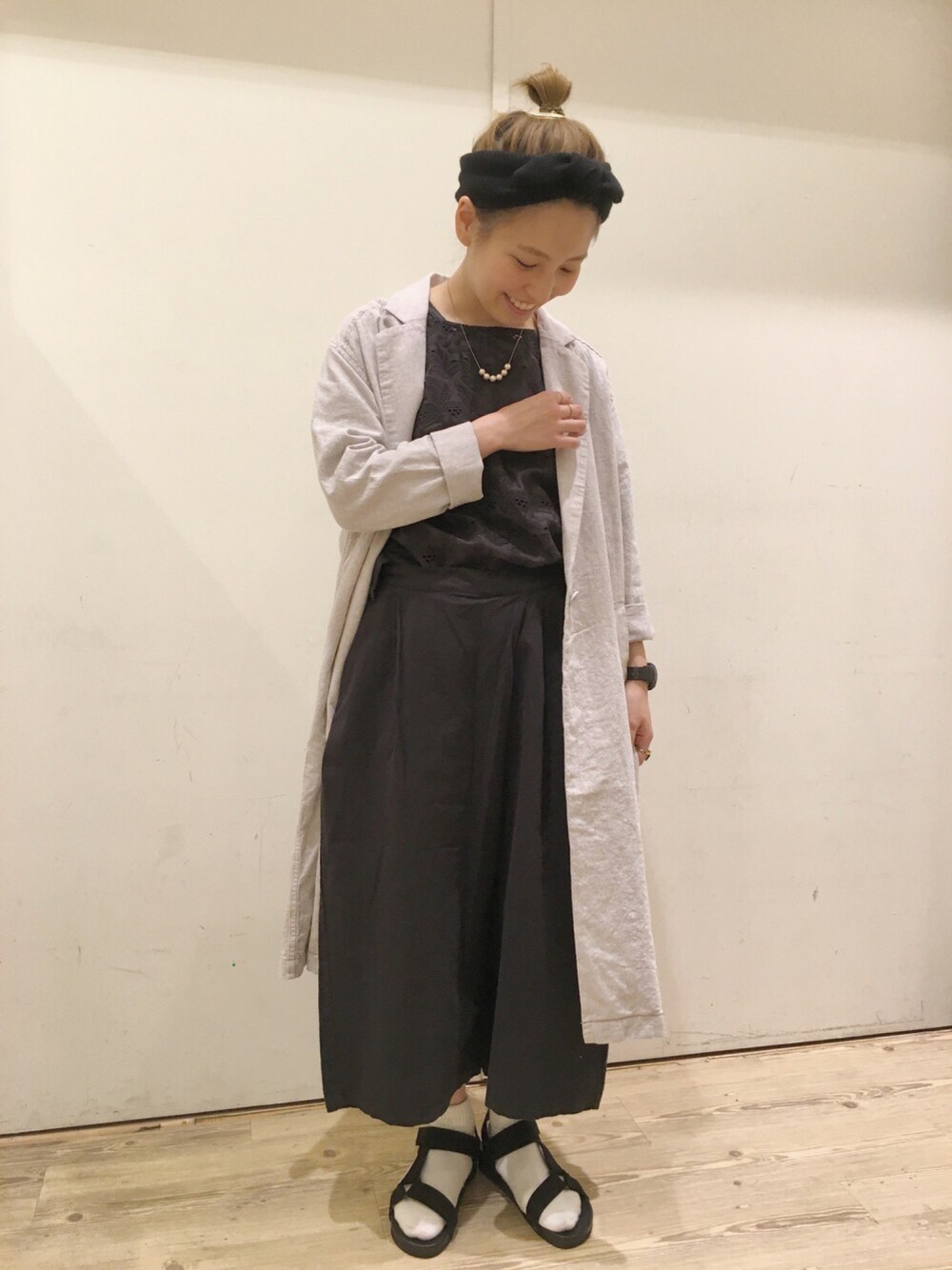 ブラック系のシャツ/ブラウス、グレー系のチェスターコート、ブラック系のサンダルを着用したレディースの春コーディネートの1枚目の写真