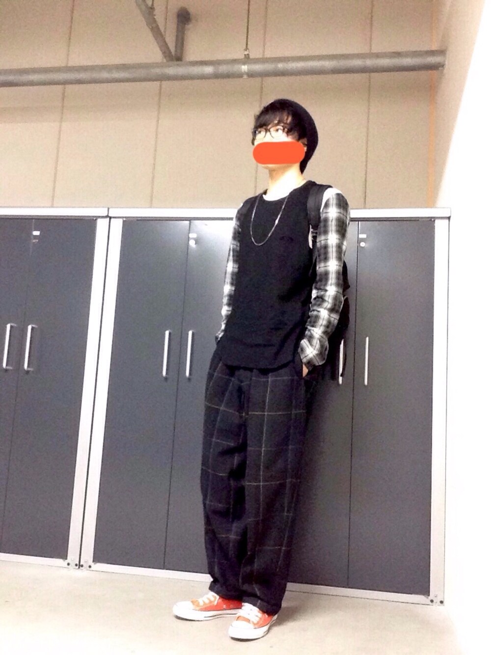 「タンクトップ、ワイドパンツ、チェックパンツ、ニットキャップ、黒縁メガネ、スニーカー、バッグパック、ビッグシルエット、オレンジ、レイヤードスタイル」｜「bukhtのポンチノースリーブカットソー（タンクトップ、ブラック系）」を使った、わみさん（メンズ・180cm）の春コーディネートの1枚目の写真