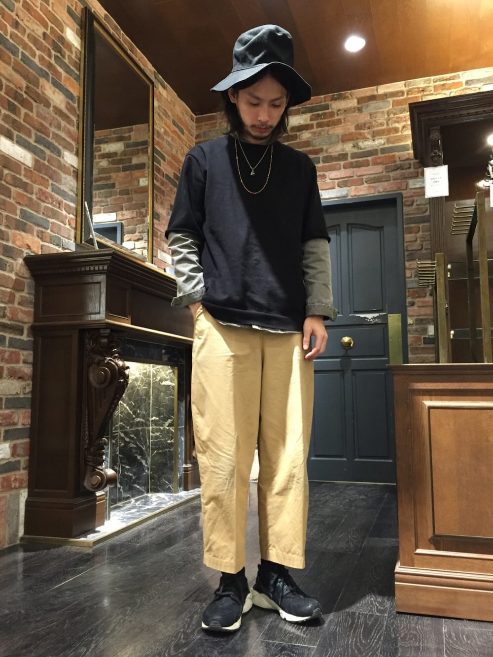 ブラック系のTシャツ/カットソー、ベージュ系のその他パンツ、ブラック系のスニーカーを着用したメンズの春コーディネートの1枚目の写真