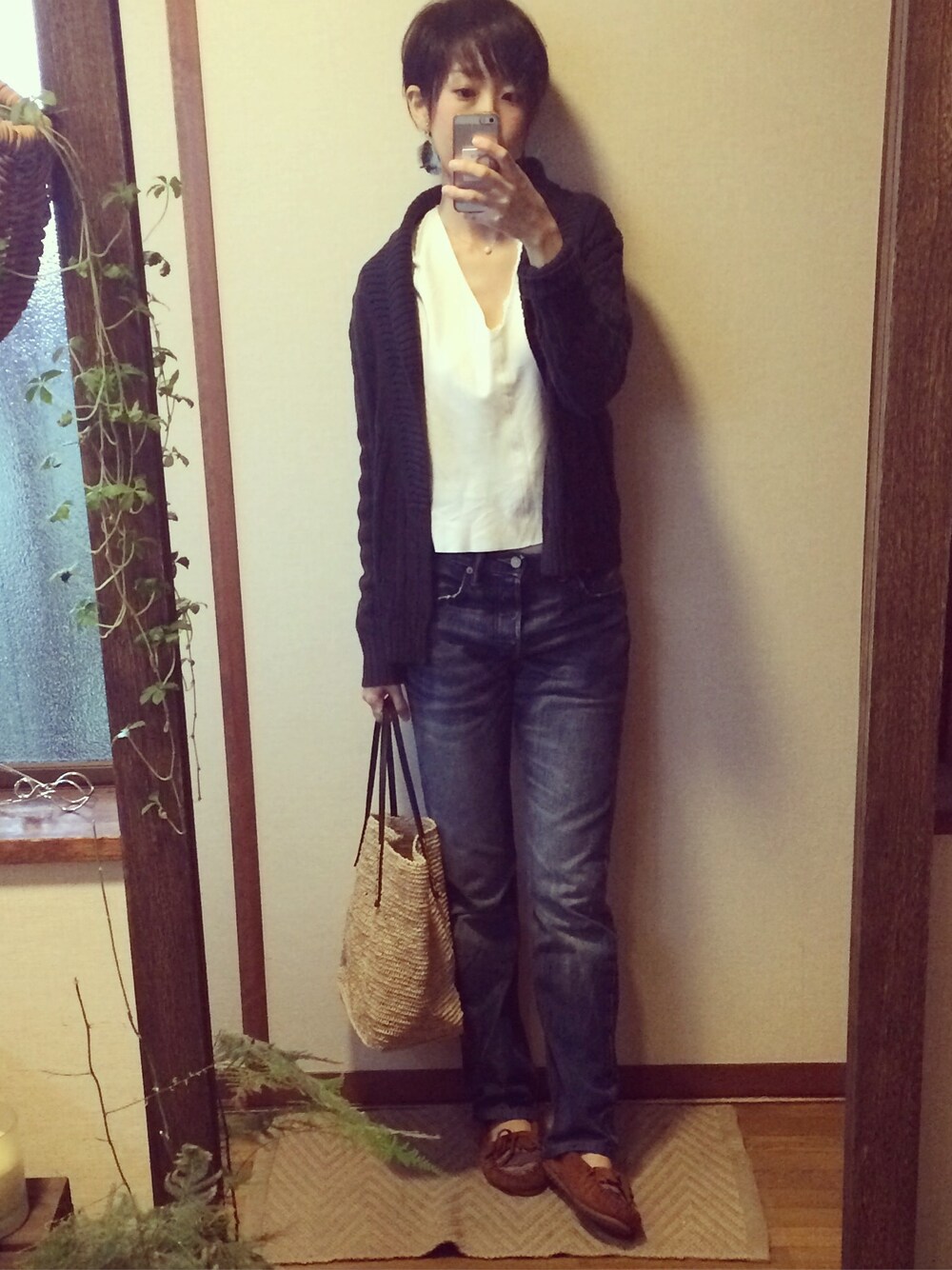 ブラウン系のかごバッグ、ブラウン系のモカシン/デッキシューズ、ブルー系のイヤリングを着用したレディースの春コーディネートの1枚目の写真