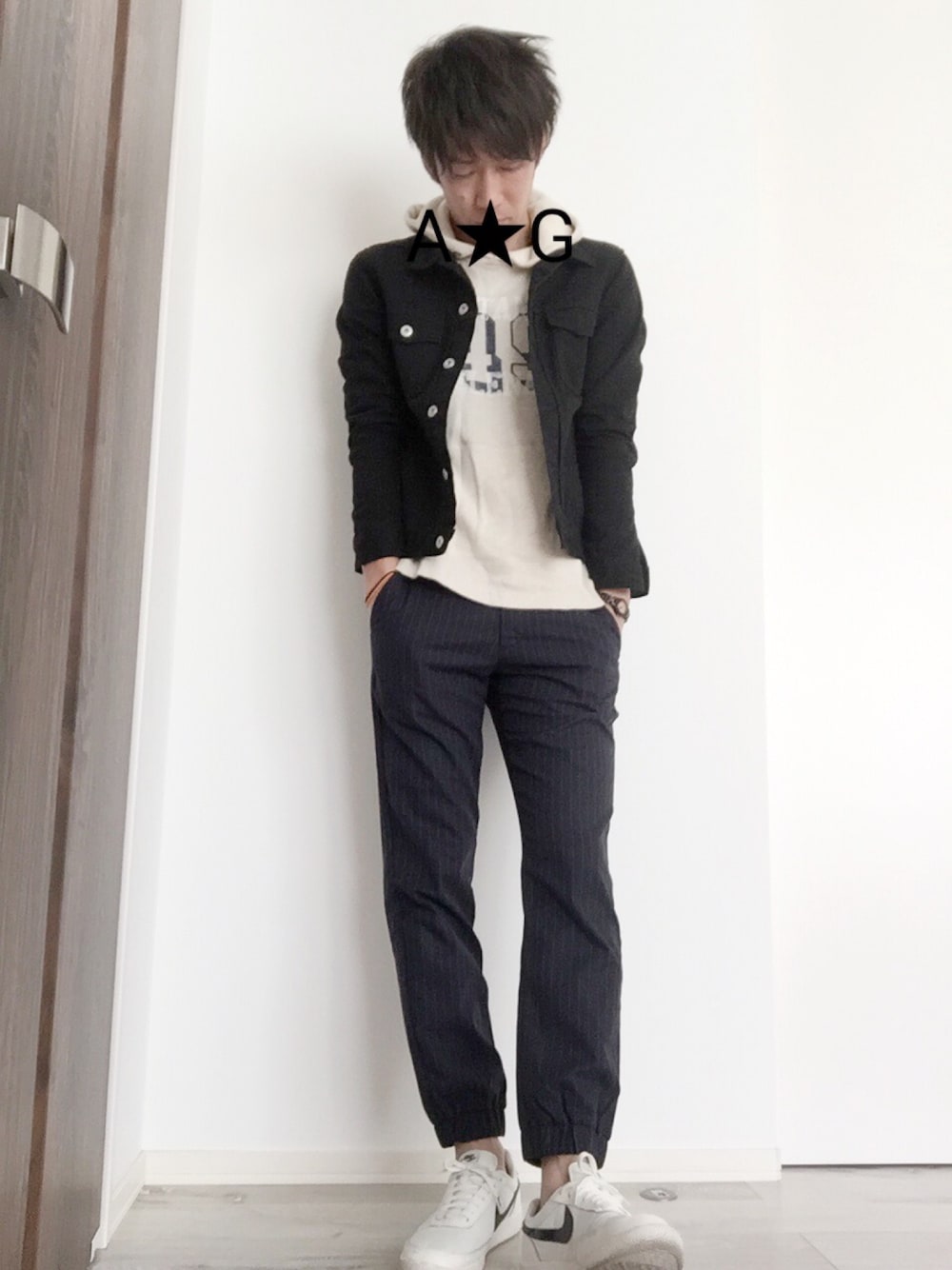 ブラック系のデニムジャケット、ホワイト系のパーカー、ブルー系のパンツを着用したメンズの春コーディネートの1枚目の写真