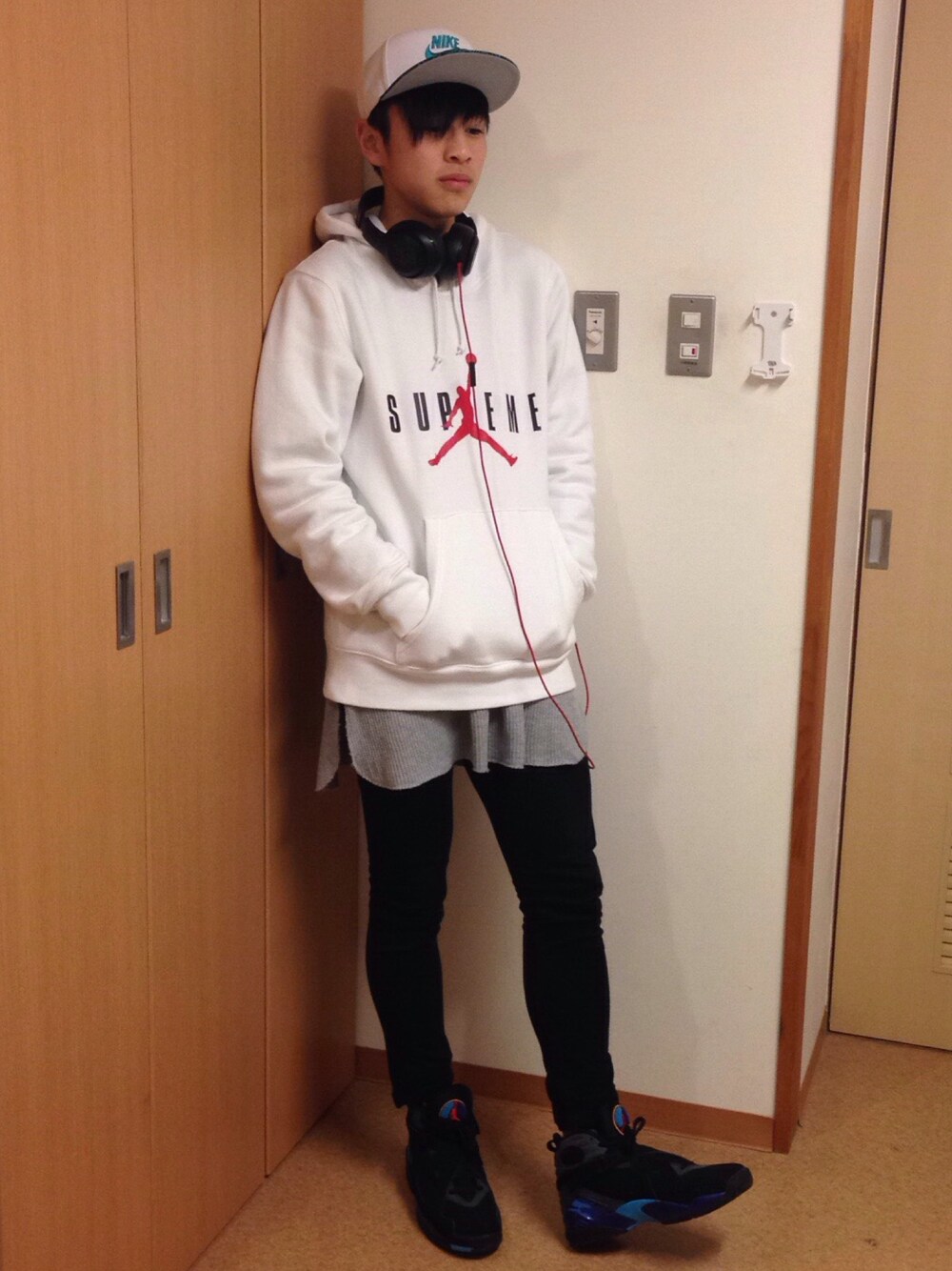 ホワイト系のパーカー、グレー系のTシャツ/カットソー、ブラック系のデニムパンツを着用したメンズの冬コーディネートの1枚目の写真