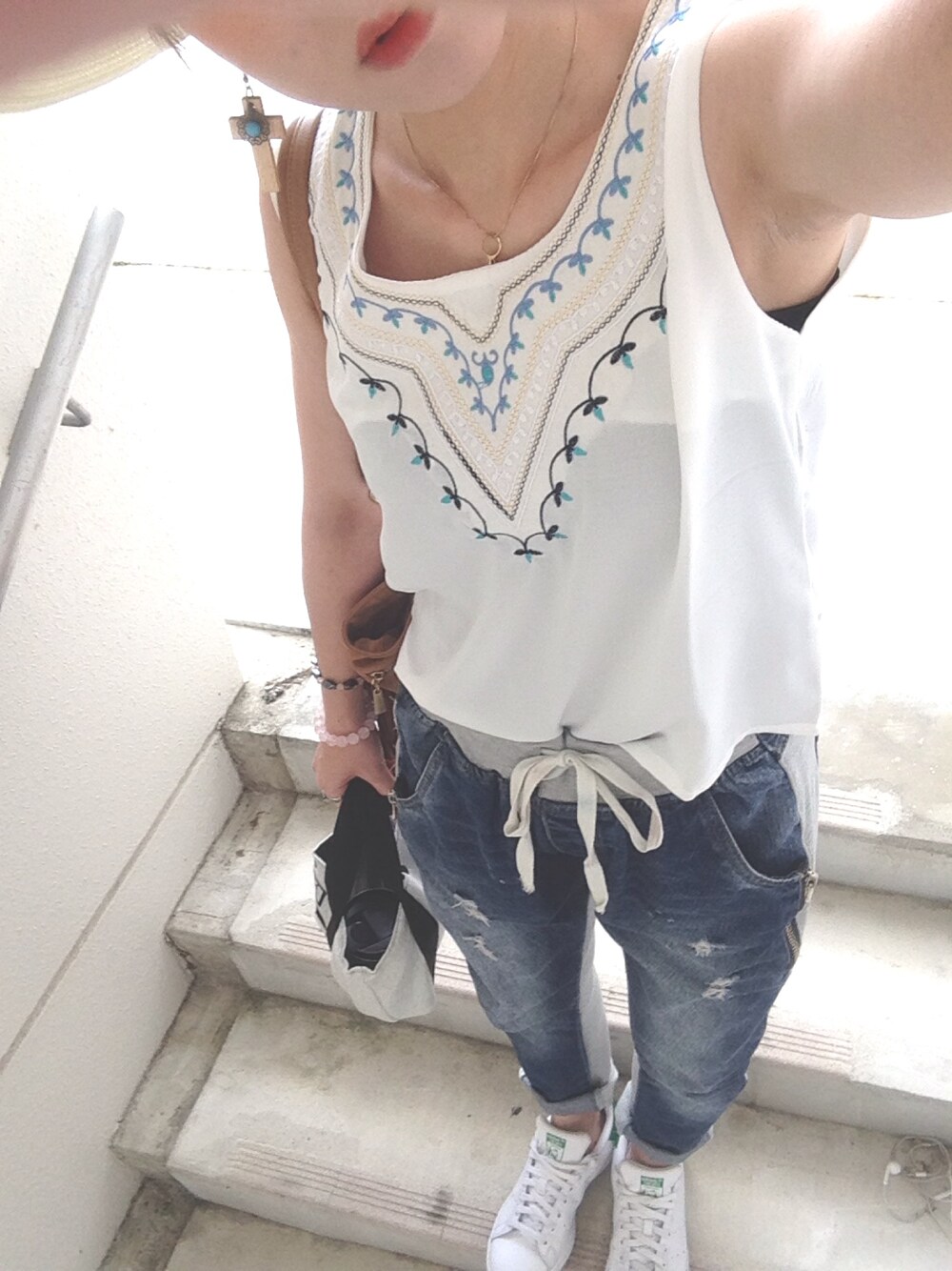 ブルー系のデニムパンツ、ホワイト系のスニーカーを着用したレディースの春コーディネートの1枚目の写真