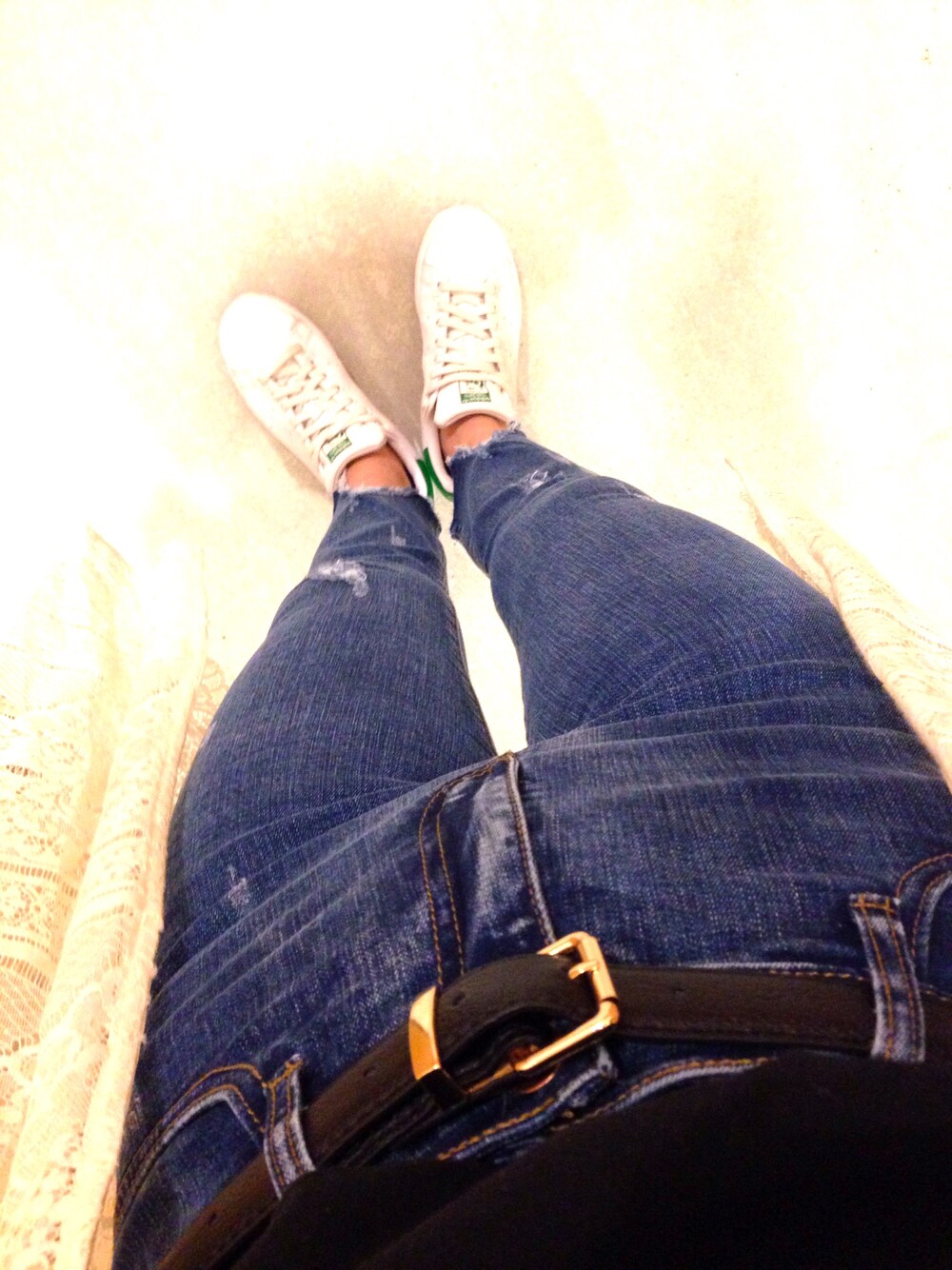 ブルー系のデニムパンツ、ホワイト系のスニーカー、ブラック系のベルトを着用したレディースの夏コーディネートの1枚目の写真