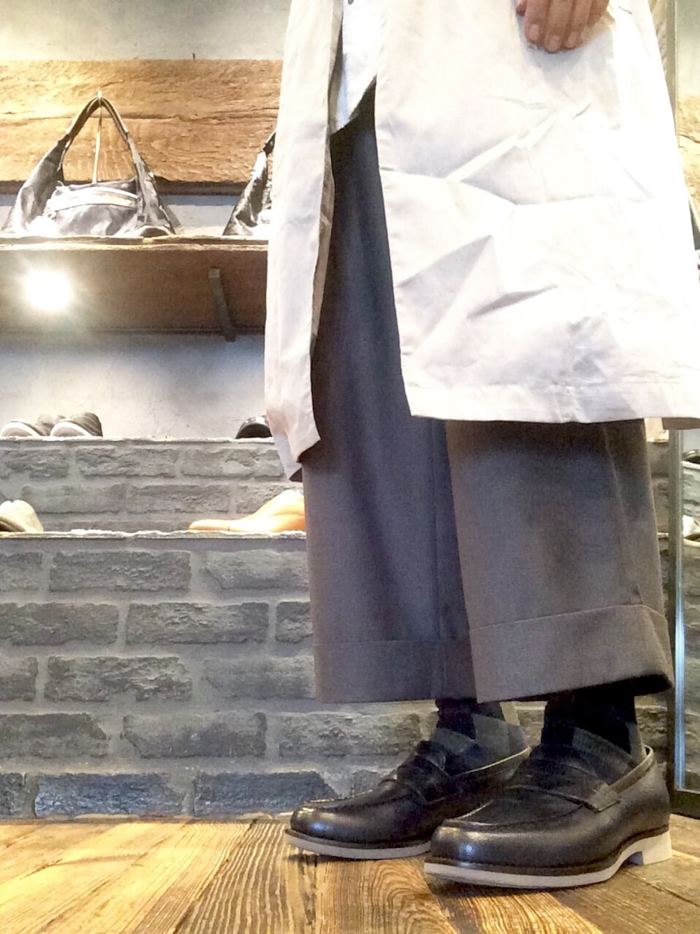 グレー系のチェスターコート、ブルー系のローファー、グレー系のその他を着用したメンズの秋コーディネートの1枚目の写真