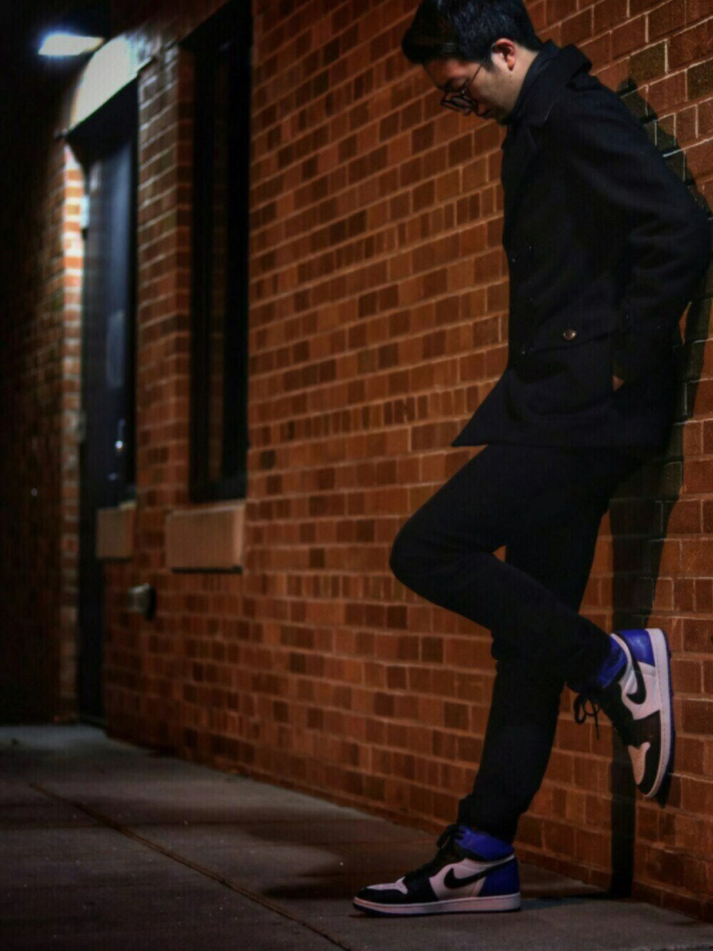 ブラック系のピーコート、ブルー系のスニーカー、ブラック系のその他パンツを着用したメンズの秋コーディネートの1枚目の写真