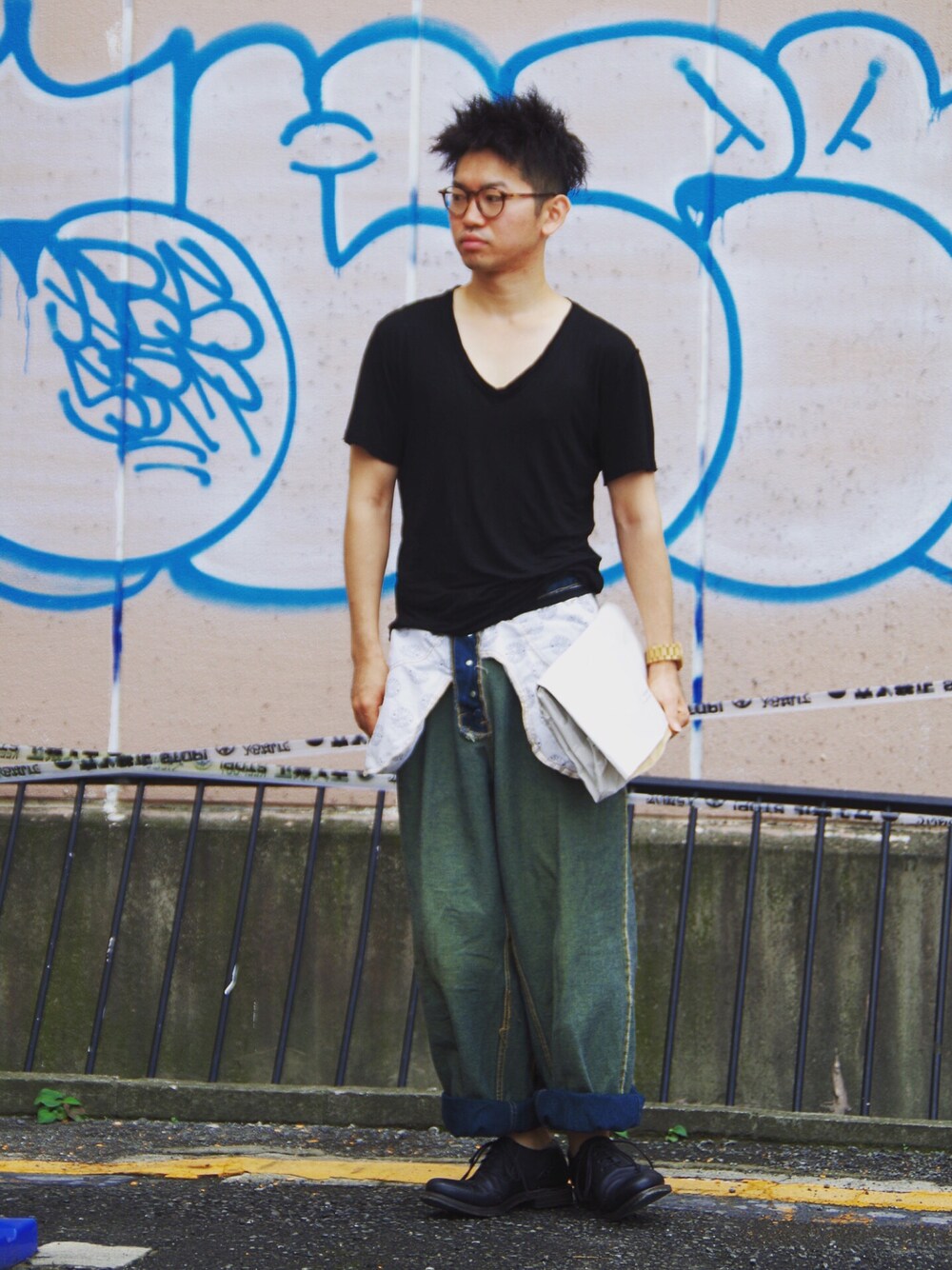 ブルー系のデニムパンツ、ホワイト系のクラッチバッグ、パープル系のドレスシューズを着用したメンズの夏コーディネートの1枚目の写真