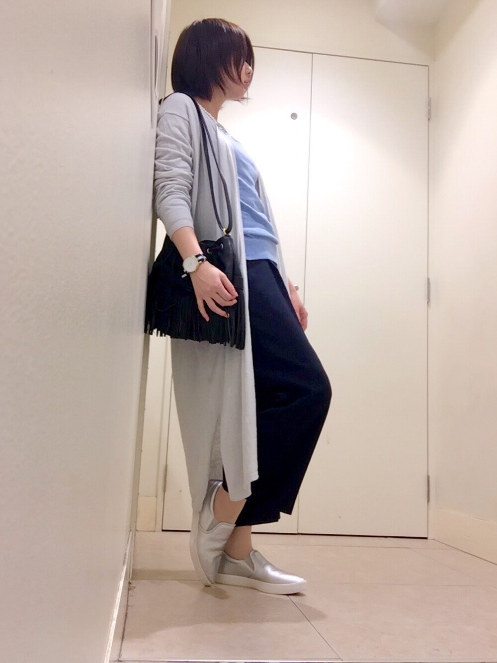 ブラック系のバッグ、ブルー系のカーディガン/ボレロ、ブルー系のパンツを着用したレディースの春コーディネートの1枚目の写真
