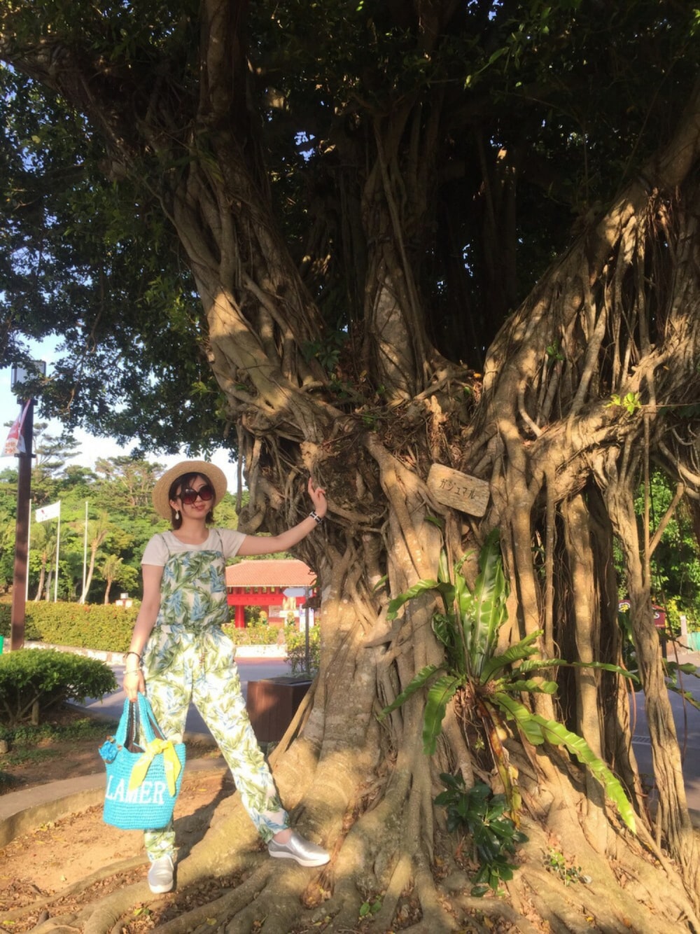 ブルー系のかごバッグ、シルバー系のシューズ、ホワイト系のTシャツ/カットソーを着用したレディースの春コーディネートの1枚目の写真