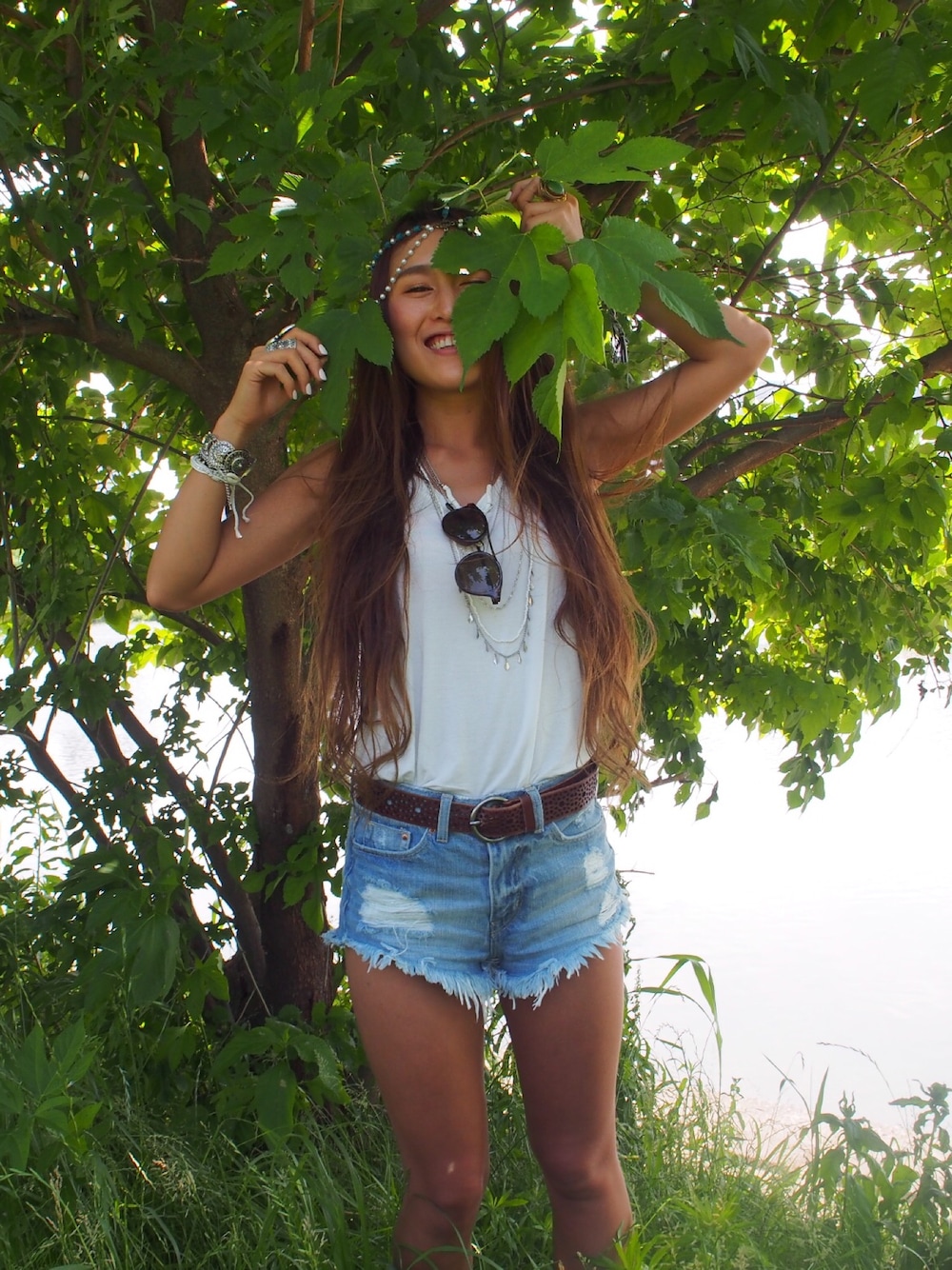 ホワイト系のタンクトップ、ブラック系のサングラス、シルバー系のブレスレットを着用したレディースの夏コーディネートの1枚目の写真