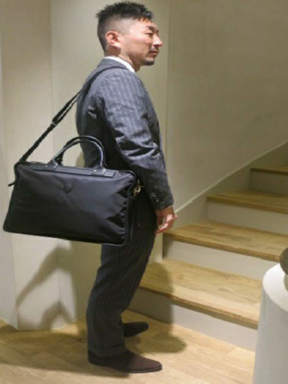 ブラック系のショルダーバッグを着用したメンズの春コーディネートの1枚目の写真