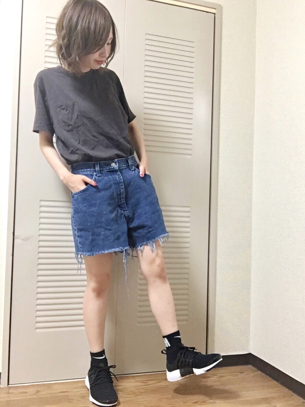 ブラック系のスニーカー、ブルー系のデニムパンツ、グレー系のTシャツ/カットソーを着用したレディースの夏コーディネートの1枚目の写真
