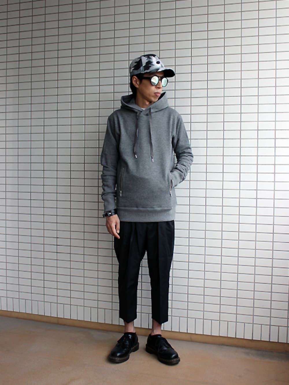 グレー系のパーカー、ブラック系のその他パンツ、グレー系のキャップを着用したメンズの秋コーディネートの1枚目の写真