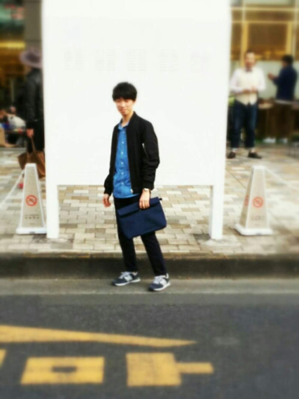 ブルー系のクラッチバッグ、ブルー系のチノパンツ、ブラック系のブルゾンを着用したメンズの秋コーディネートの1枚目の写真