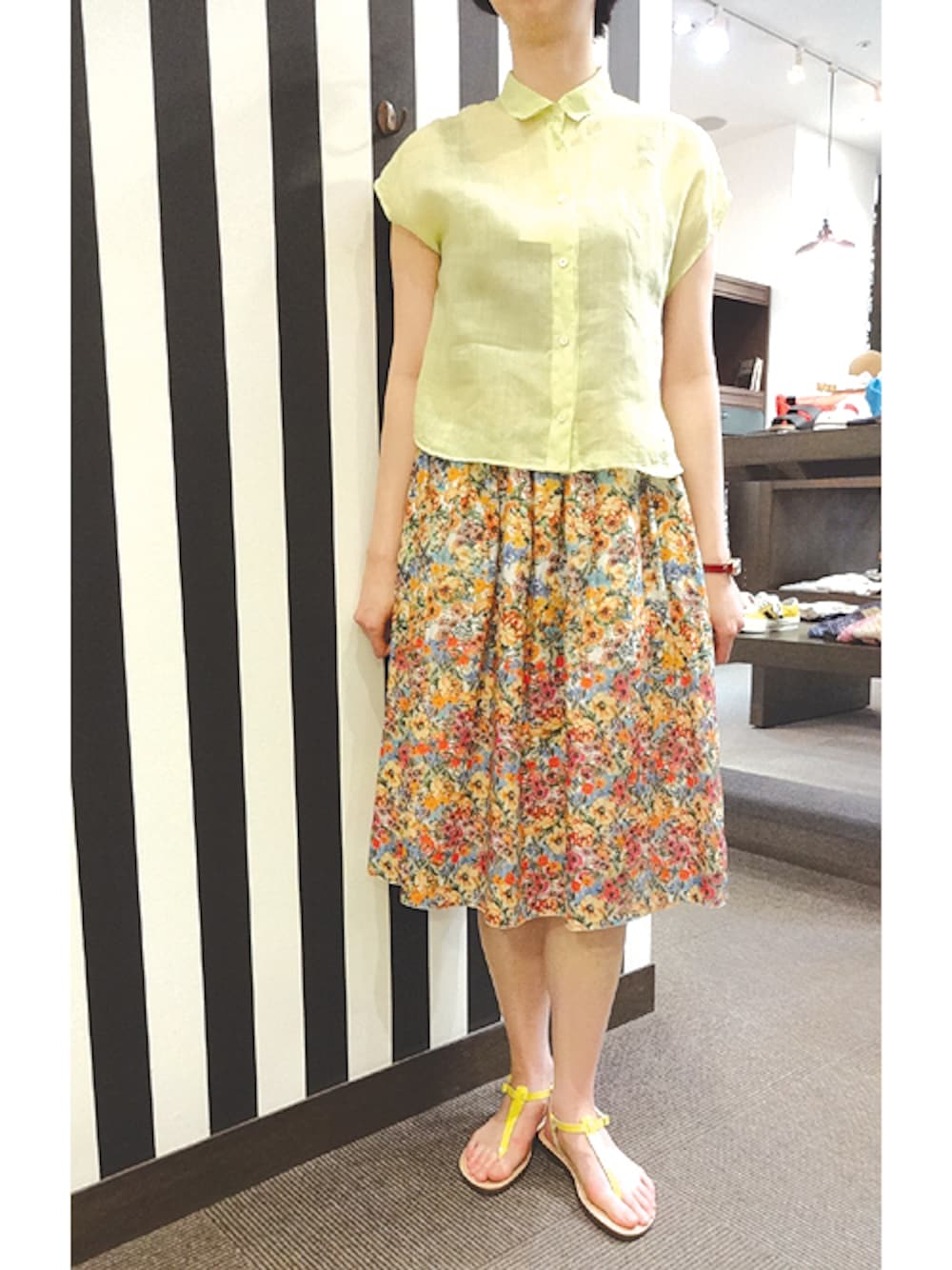 イエロー系のサンダルを着用したレディースの春コーディネートの1枚目の写真