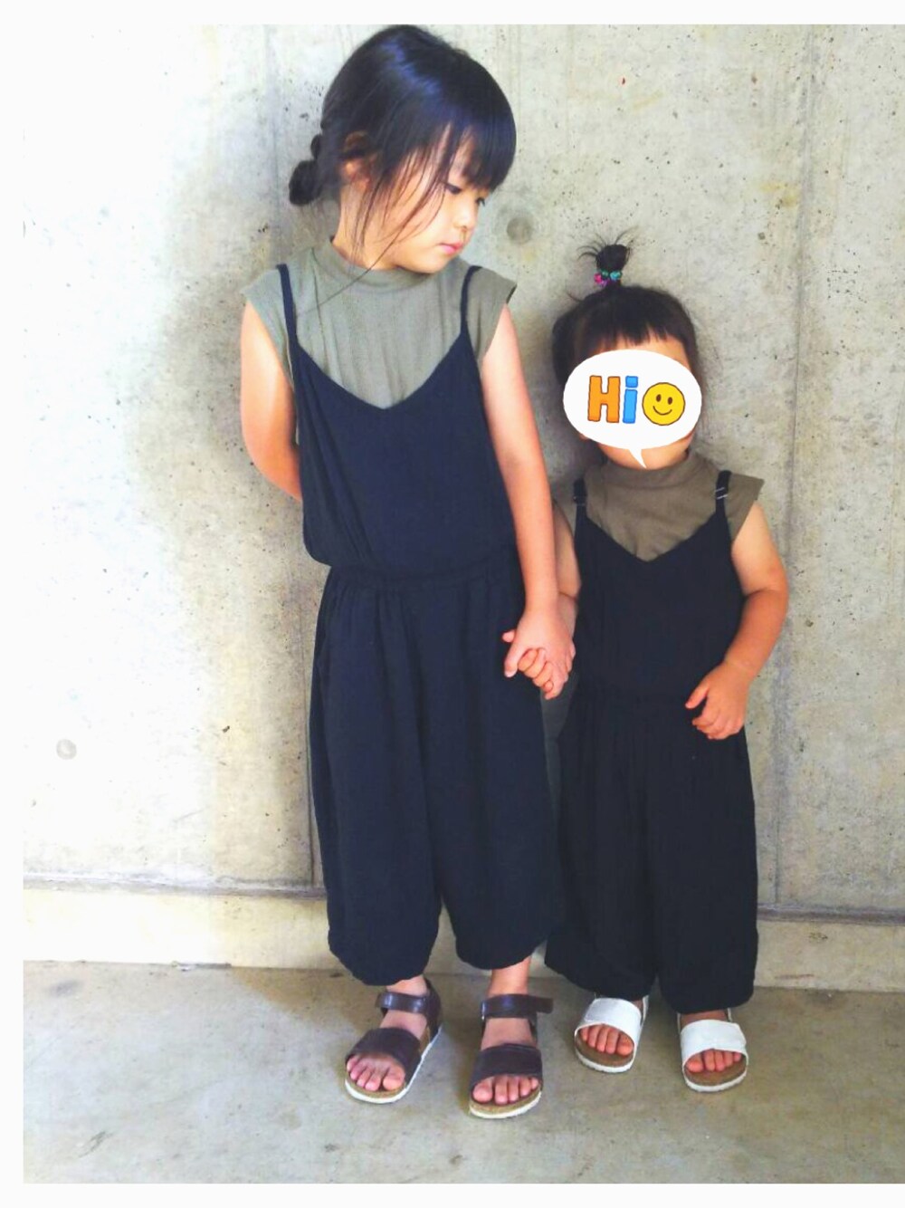 ブラック系のサロペット/オーバーオール、グリーン系のTシャツ/カットソー、ブラウン系のサンダルを着用したキッズの秋コーディネートの1枚目の写真