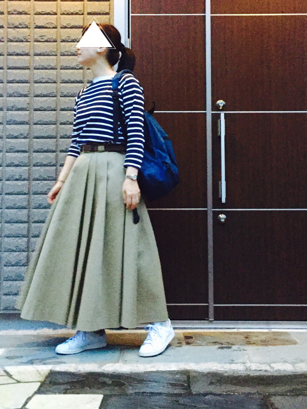 ブルー系のTシャツ/カットソー、ブルー系のバックパック/リュック、グリーン系のスカートを着用したレディースの秋コーディネートの1枚目の写真