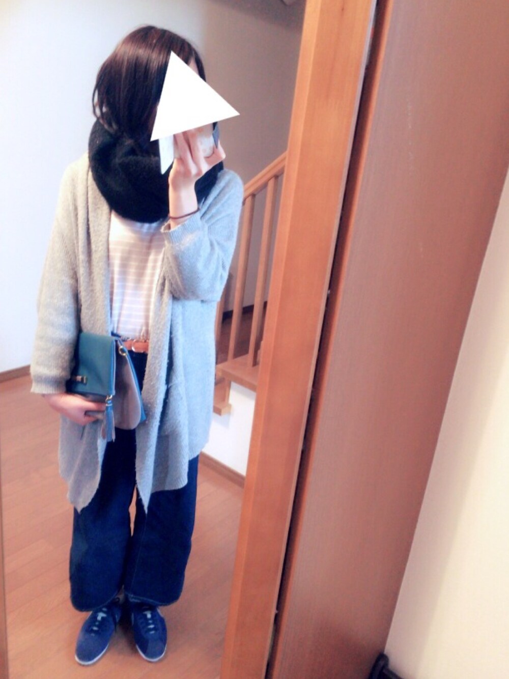 グレー系のポンチョ、ブルー系のデニムパンツ、ブルー系のスニーカーを着用したレディースの秋コーディネートの1枚目の写真