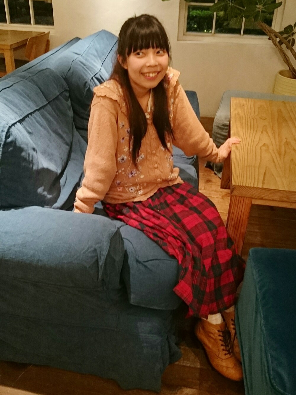 ブラウン系のトップス、レッド系のスカート、ブラウン系のシューズを着用したレディースの秋コーディネートの1枚目の写真