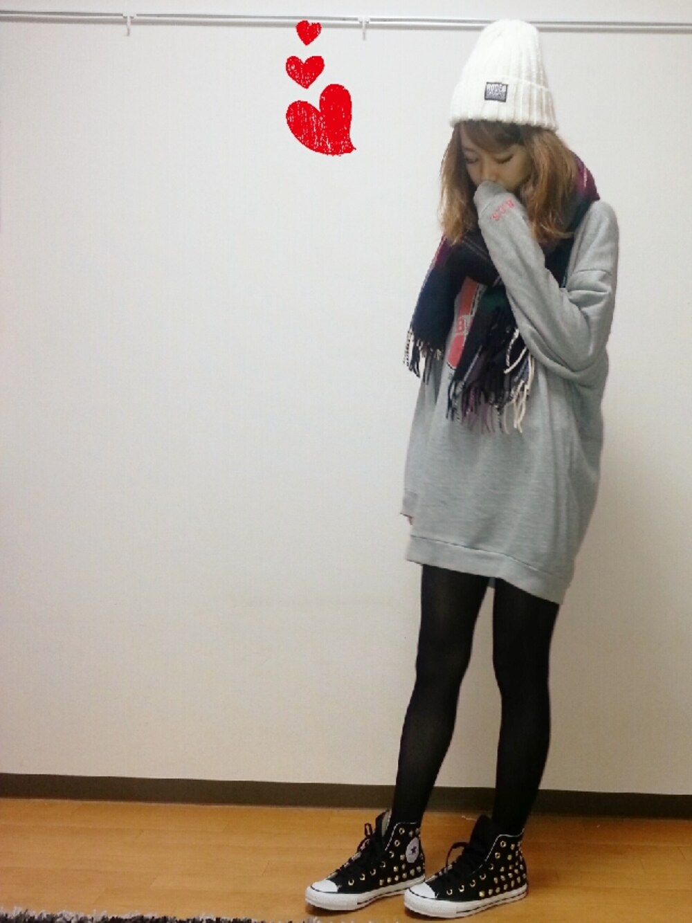 グレー系のワンピース、ブラック系のスニーカー、ホワイト系のニットキャップ/ビーニーを着用したレディースの冬コーディネートの1枚目の写真