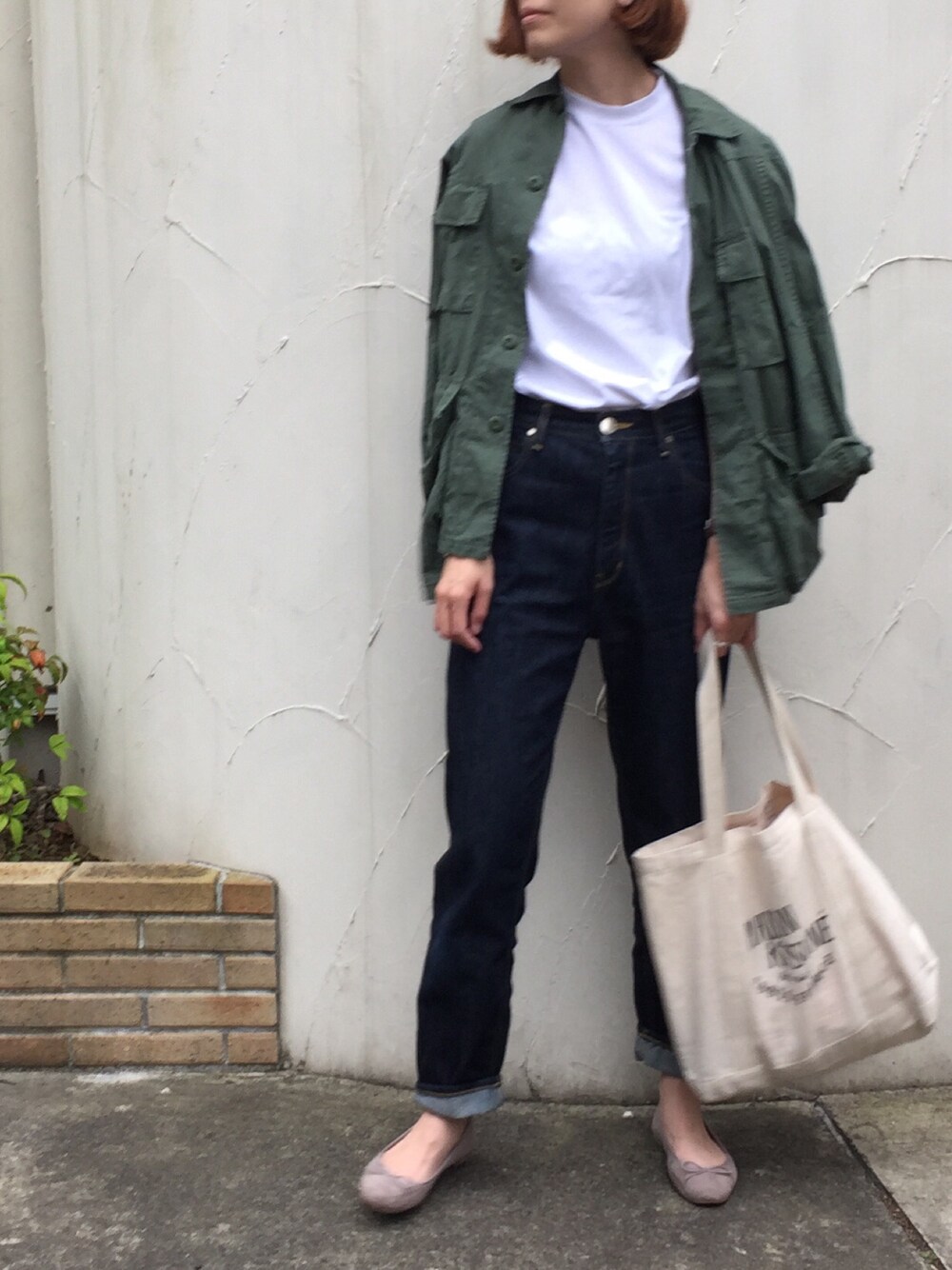 グリーン系のミリタリージャケット、ホワイト系のTシャツ/カットソー、ブルー系のデニムパンツを着用したレディースの春コーディネートの1枚目の写真