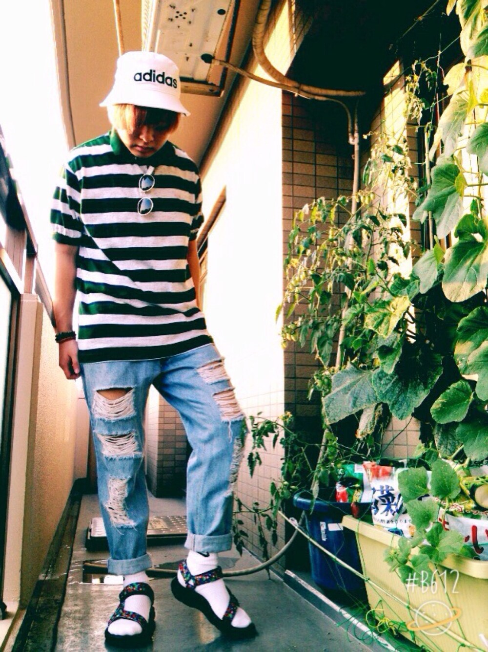 グリーン系のポロシャツ、ブルー系のデニムパンツ、ブラック系のサンダルを着用したメンズの夏コーディネートの1枚目の写真