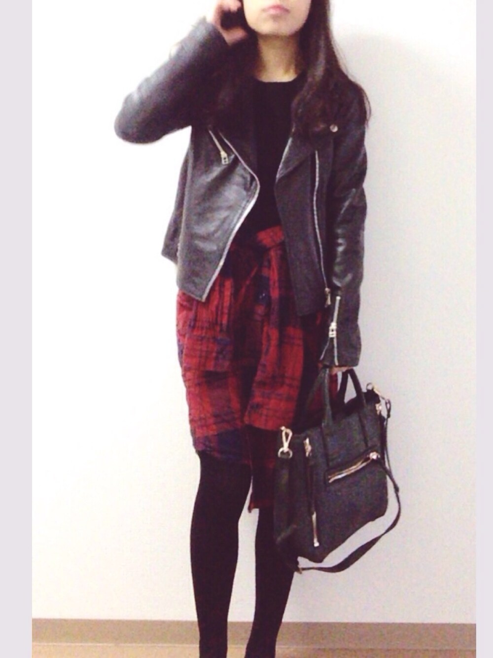 ブラック系のライダースジャケットを着用したレディースの冬コーディネートの1枚目の写真