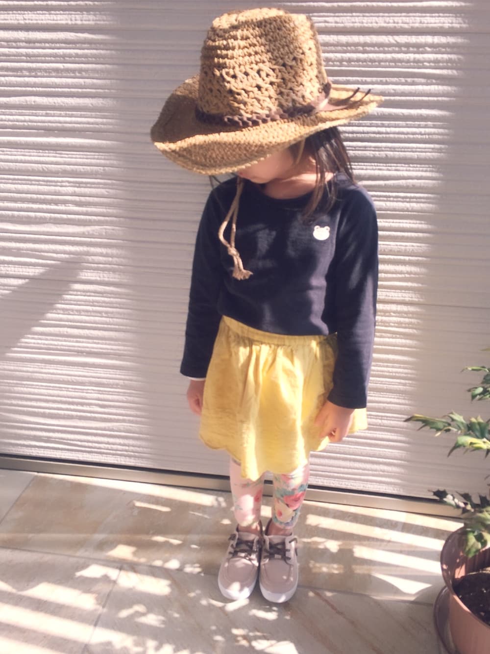 ブラック系のTシャツ/カットソー、イエロー系のスカート、ブラック系のシューズを着用したキッズの春コーディネートの1枚目の写真