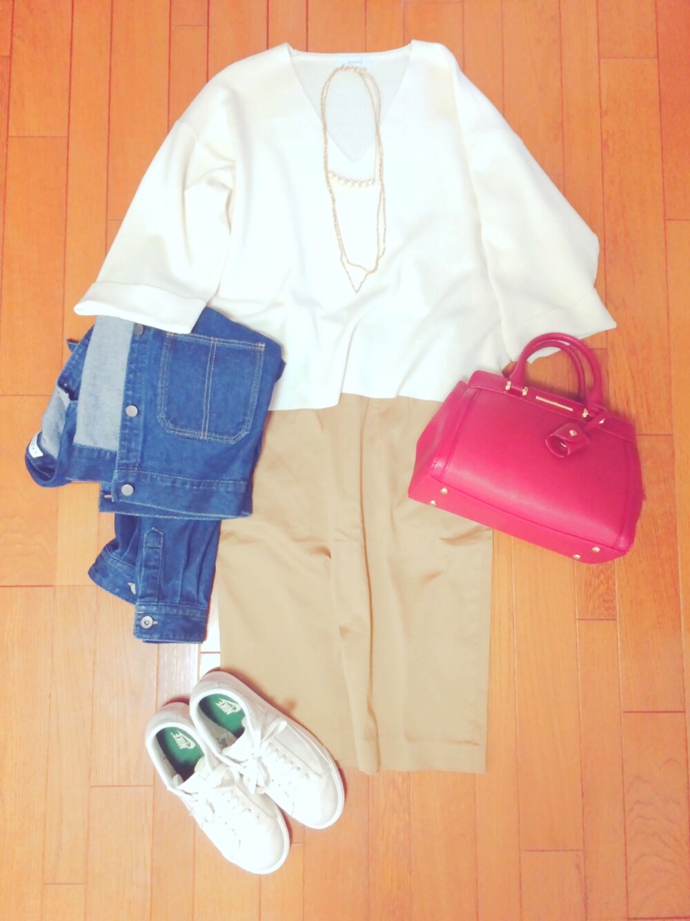 ホワイト系のニット/セーター、レッド系のボストンバッグ、ブルー系のデニムジャケットを着用したレディースの春コーディネートの1枚目の写真