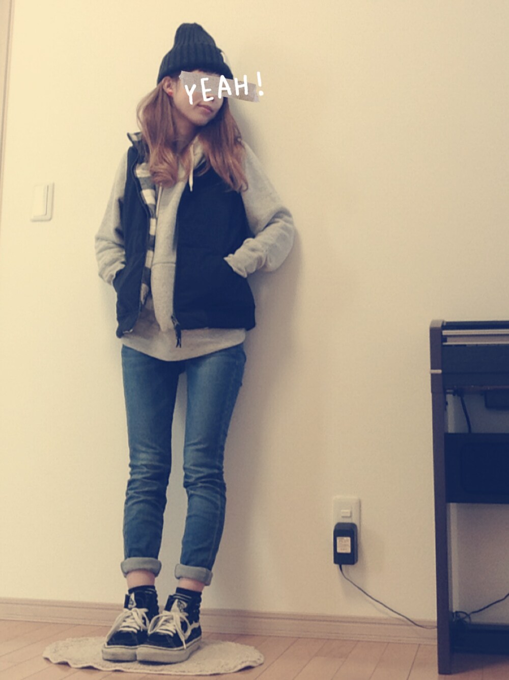 ブラック系のダウンベスト、ブルー系のデニムパンツ、ブラック系のスニーカーを着用したレディースの冬コーディネートの1枚目の写真