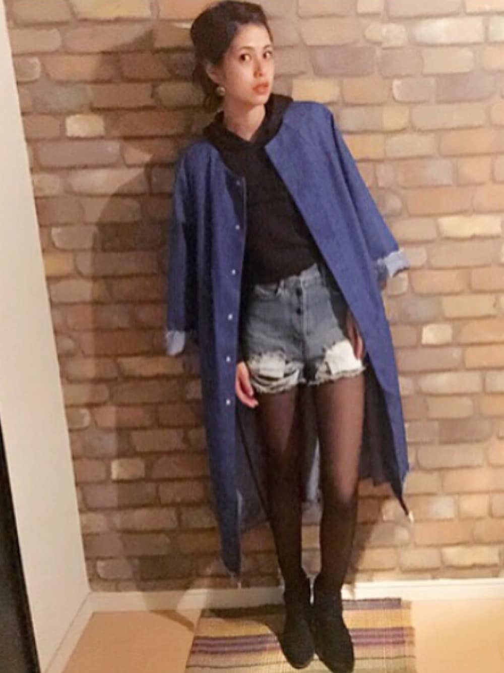 ブルー系のデニムジャケット、ブルー系のデニムパンツ、ブラック系のブーティを着用したレディースの秋コーディネートの1枚目の写真