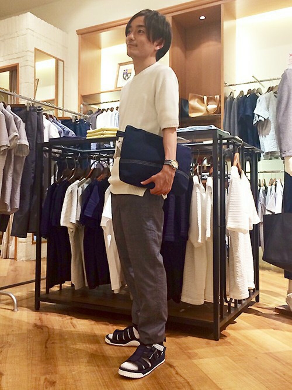 ホワイト系のTシャツ/カットソー、ブルー系のチノパンツ、ブルー系のクラッチバッグを着用したメンズの春コーディネートの1枚目の写真