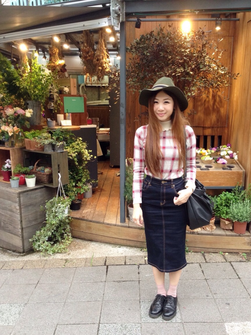 ホワイト系のニット/セーター、ブルー系のデニムスカート、ブラック系のショルダーバッグを着用したレディースの春コーディネートの1枚目の写真