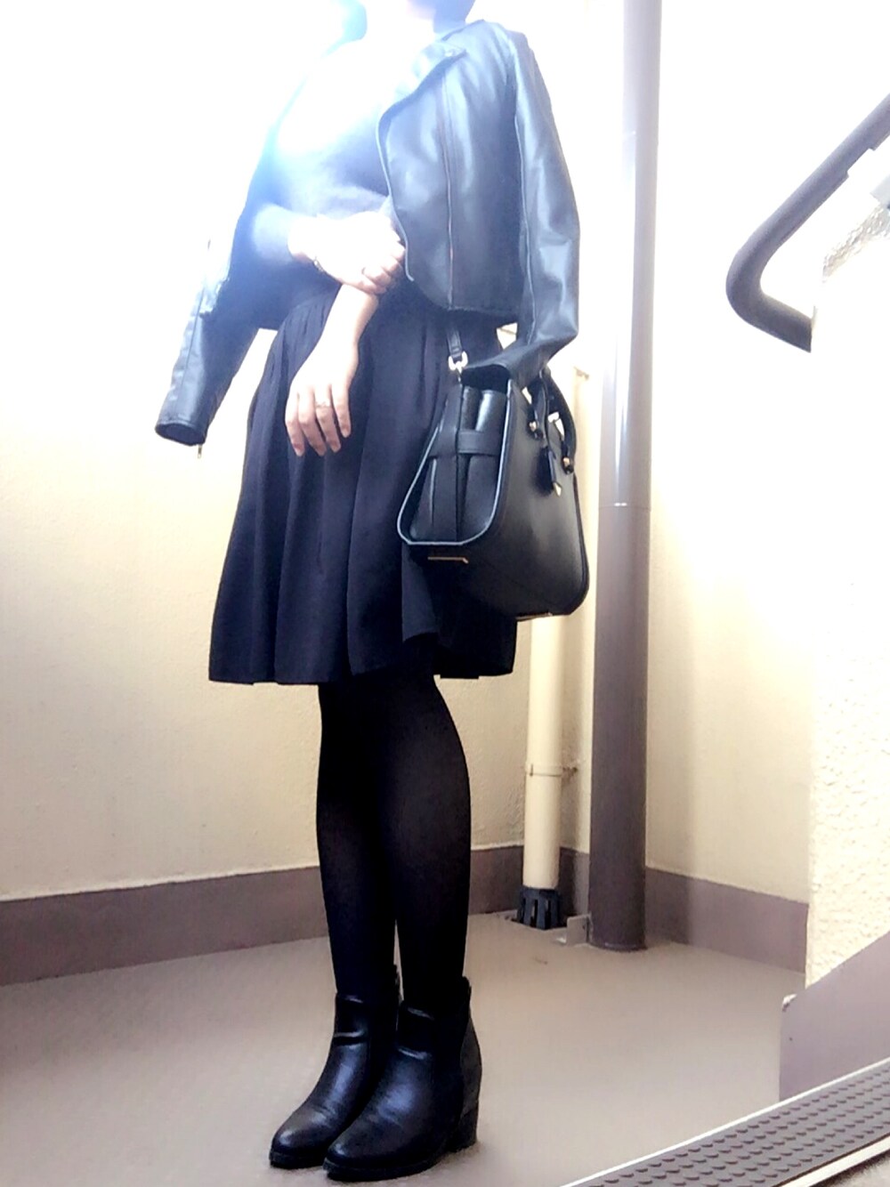 ブラック系のショルダーバッグ、ブラック系のブーツ、ブラック系のスカートを着用したレディースの秋コーディネートの1枚目の写真