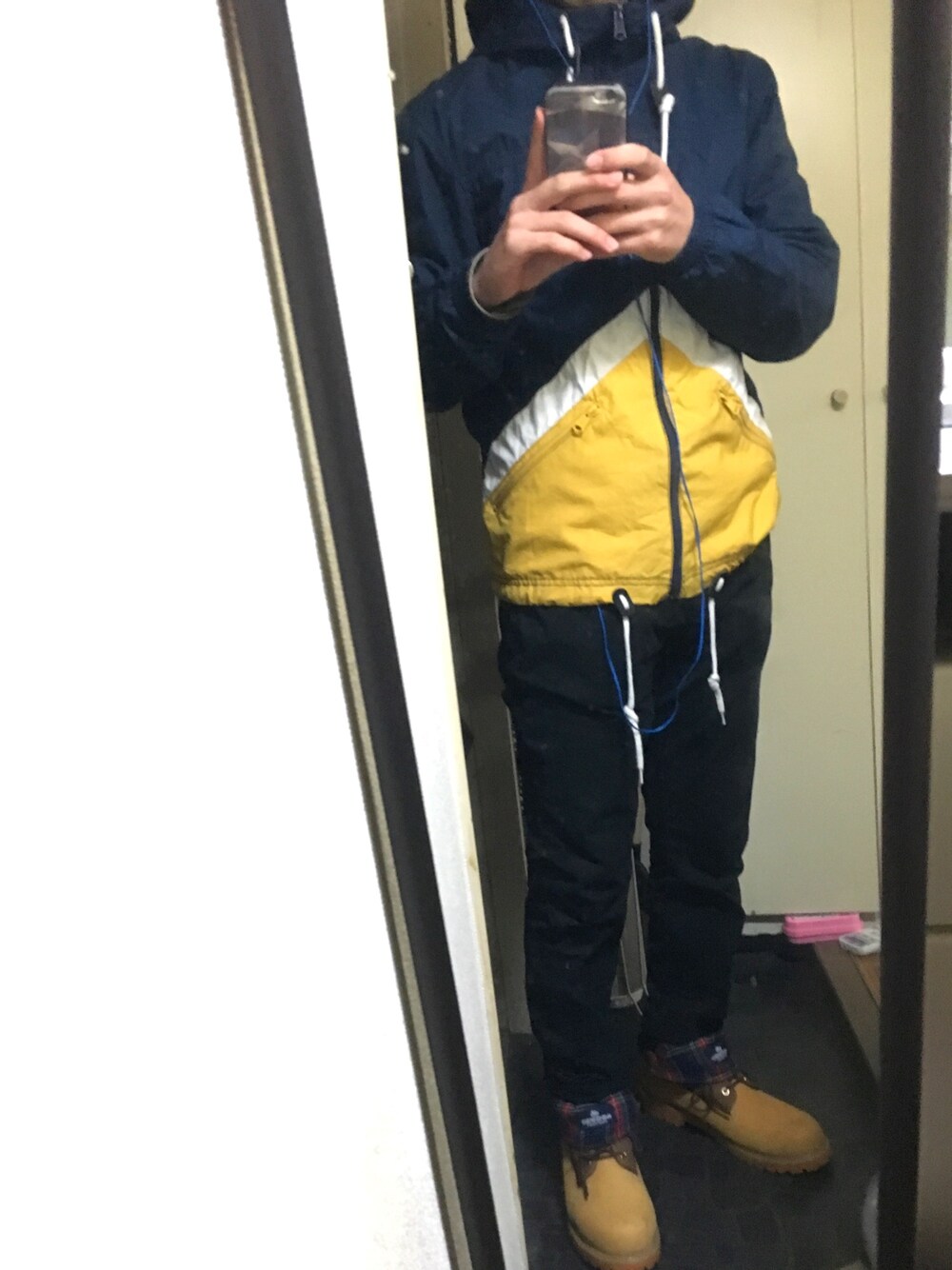 ブルー系のマウンテンパーカー、ブラック系のその他パンツ、イエロー系のブーツを着用したメンズの冬コーディネートの1枚目の写真