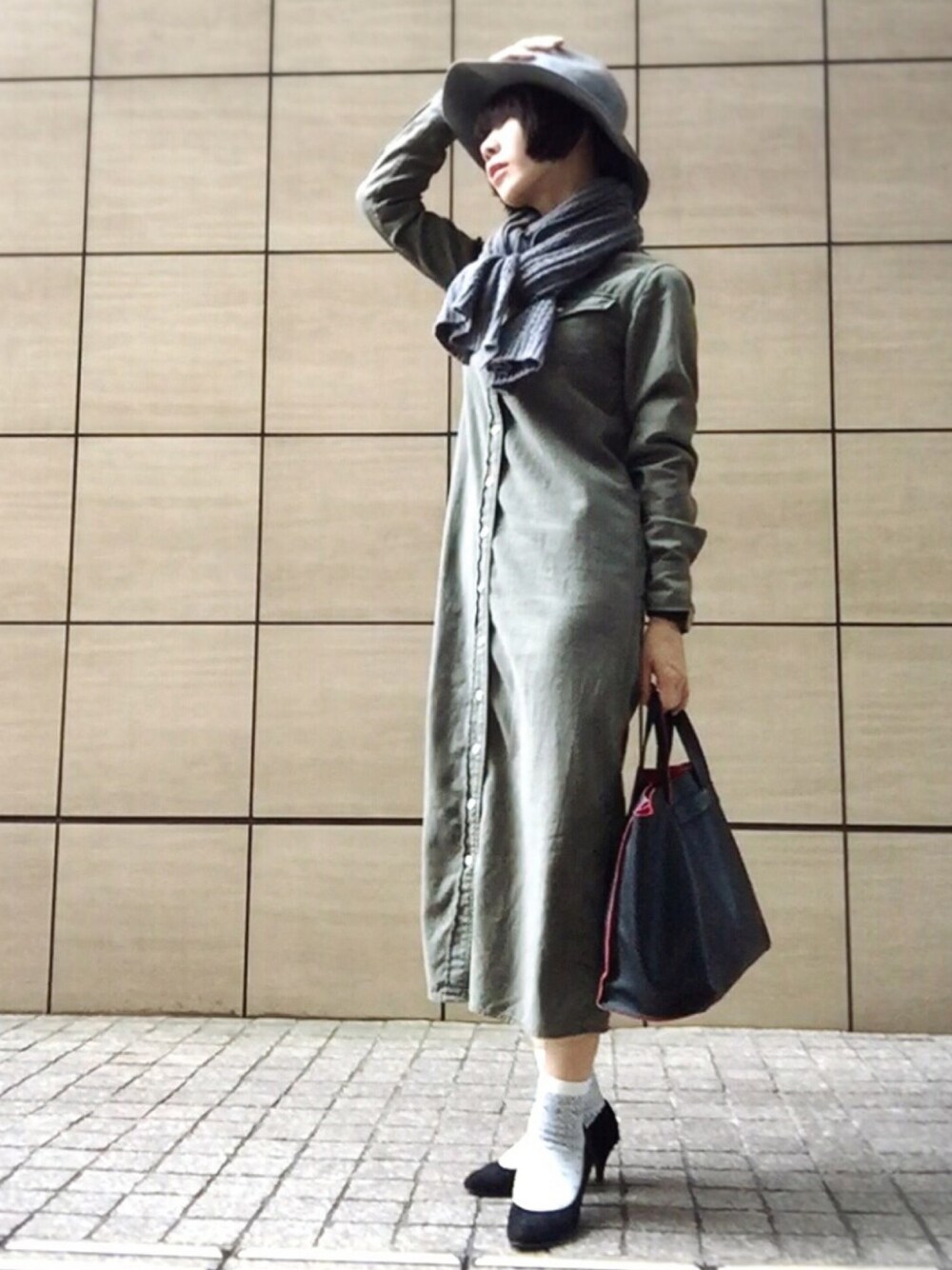 グリーン系のワンピース、ブラック系のパンプス、グレー系のマフラーを着用したレディースの秋コーディネートの1枚目の写真