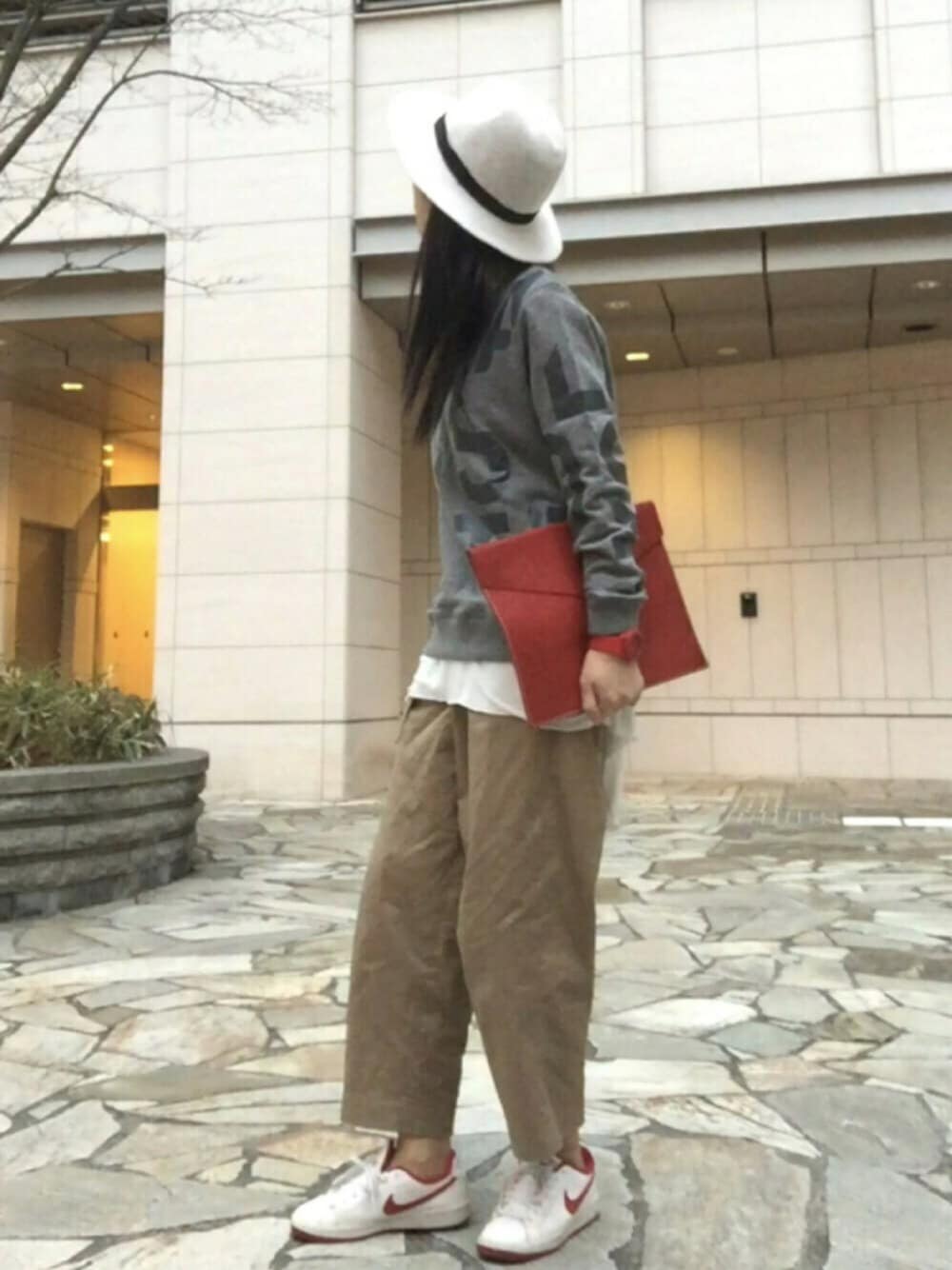 グレー系のスウェット、ホワイト系のTシャツ/カットソー、レッド系のクラッチバッグを着用したレディースの春コーディネートの1枚目の写真