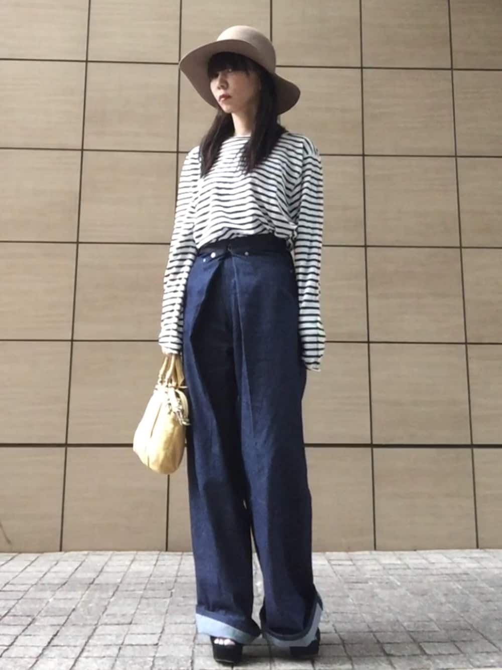 ホワイト系のTシャツ/カットソー、ブルー系のデニムパンツ、イエロー系のショルダーバッグを着用したレディースの春コーディネートの1枚目の写真