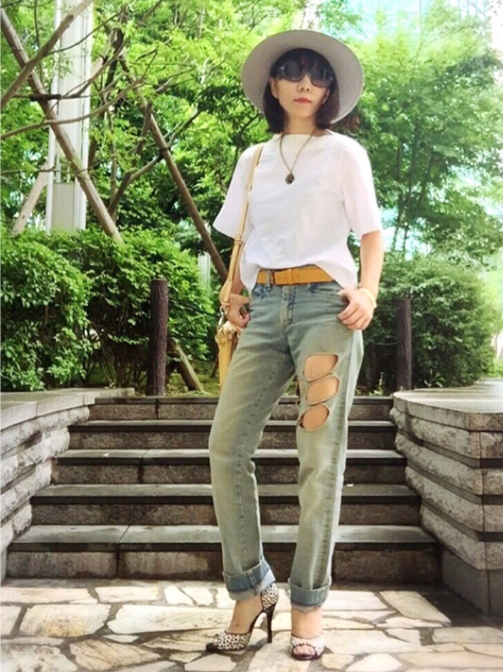 ブルー系のデニムパンツ、イエロー系のパンプス、ホワイト系のトップスを着用したレディースの夏コーディネートの1枚目の写真