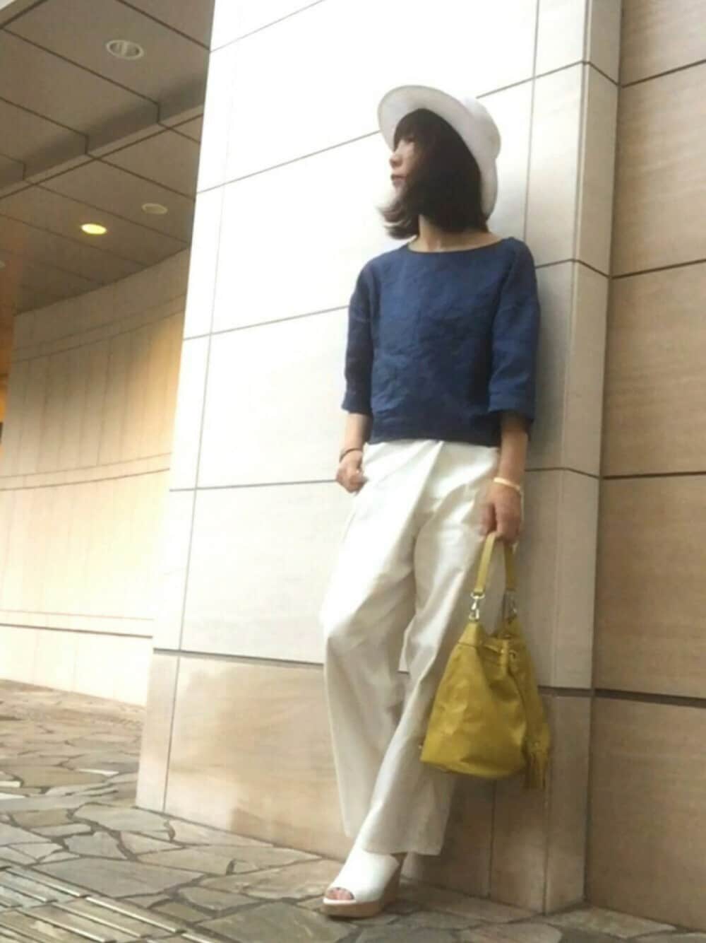 ホワイト系のパンツ、イエロー系のショルダーバッグ、ホワイト系のサンダルを着用したレディースの夏コーディネートの1枚目の写真