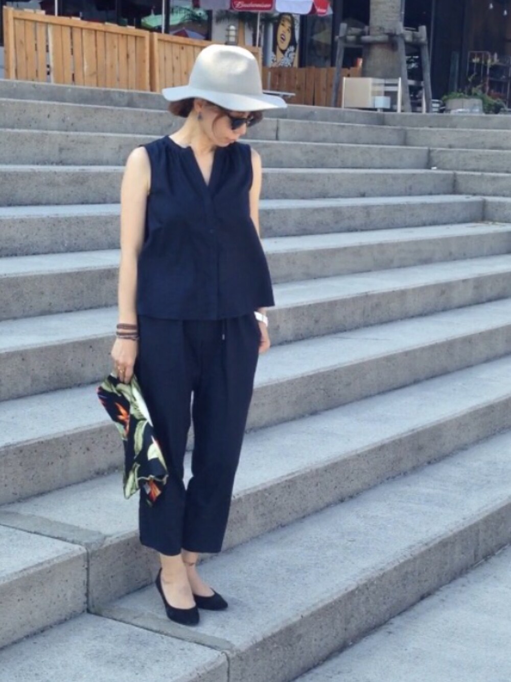 その他のクラッチバッグ、ブラック系のパンプス、ブラック系のサングラスを着用したレディースの夏コーディネートの1枚目の写真