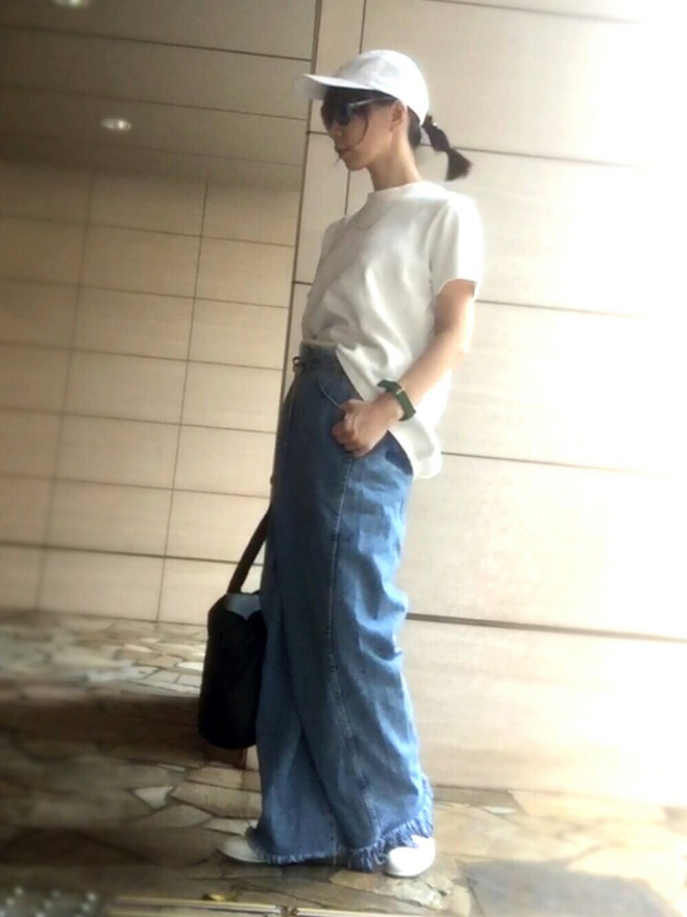 ホワイト系のトップス、ブルー系のデニムパンツ、ブラック系のトートバッグを着用したレディースの夏コーディネートの1枚目の写真