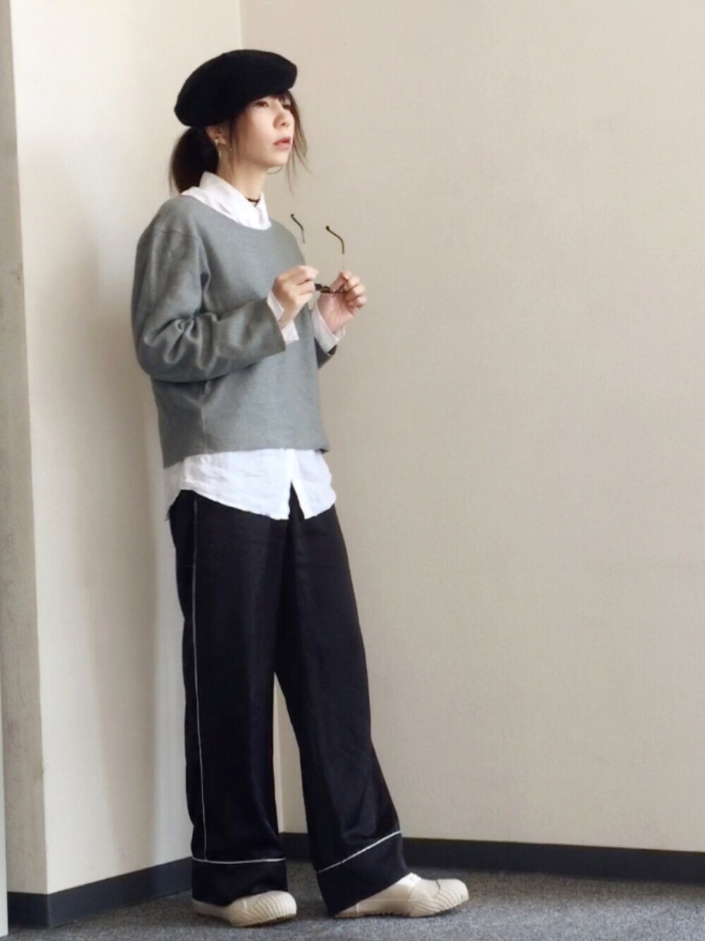 グレー系のニット/セーター、ホワイト系のシャツ/ブラウス、ブラック系のその他パンツを着用したレディースの秋コーディネートの1枚目の写真