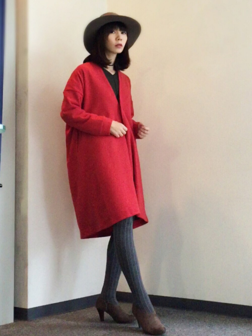 レッド系のカーディガン/ボレロ、ベージュ系のブーティ、グリーン系のワンピースを着用したレディースの秋コーディネートの1枚目の写真