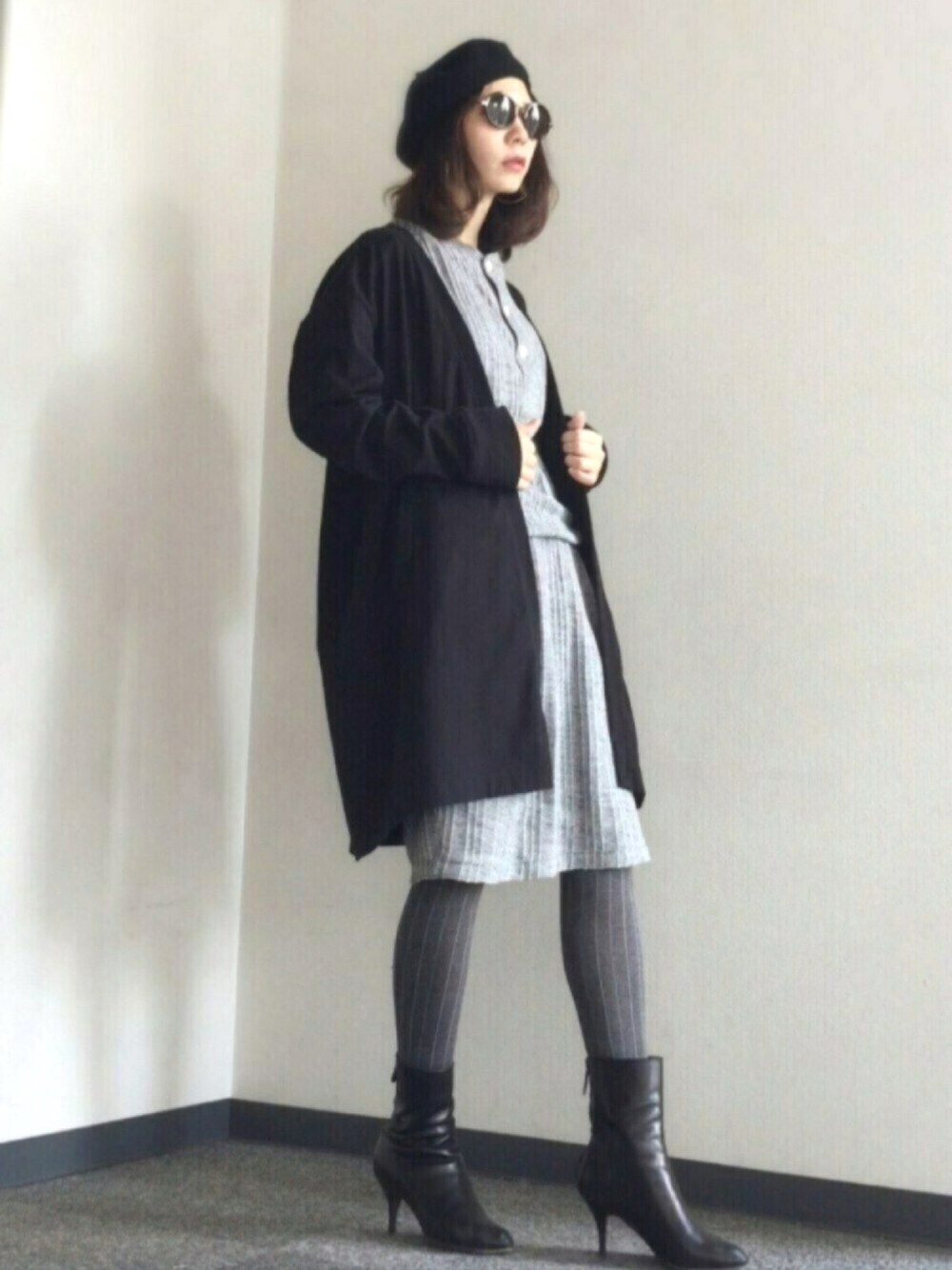 ブラック系のカーディガン/ボレロ、グレー系のワンピース、ブラック系のブーツを着用したレディースの秋コーディネートの1枚目の写真